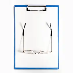 photo d'une feuille A4 blanche vierge avec une paire de lunette posée dessus